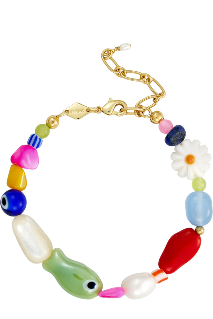 A gold-tone chain bracelet with colorful, organic-shaped beads, including a green fish bead, a white daisy, and blue evil eye beads, shown on a plain white background.