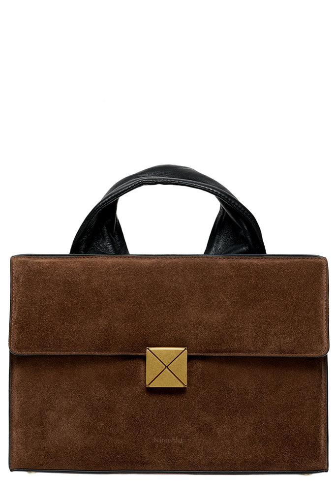 A brown suede top-handle handbag with a black leather handle and a gold-tone metal accent on the front flap, shown against a plain white background.