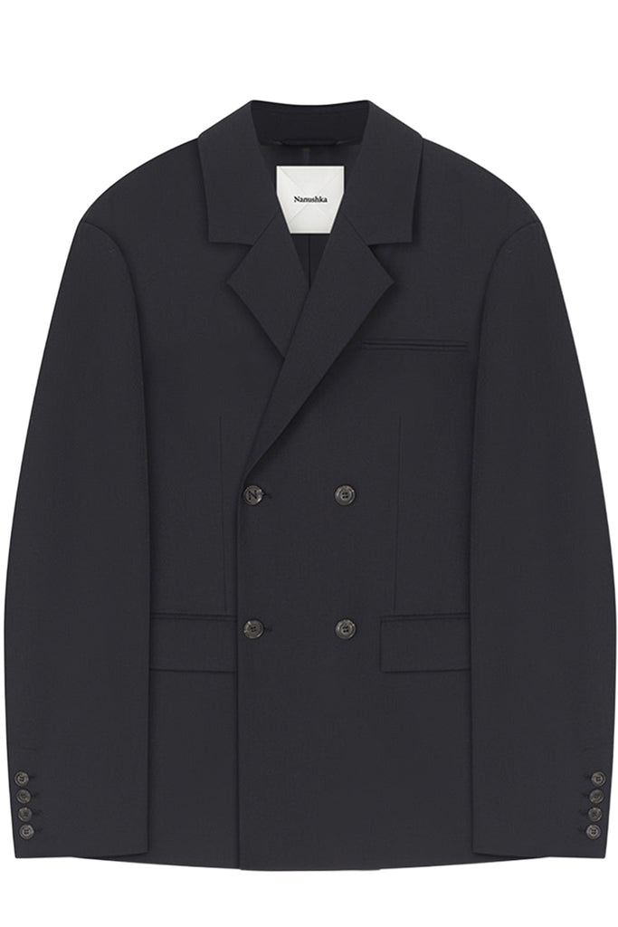 A black double-breasted blazer with a notched lapel, flat front pockets, and buttoned cuffs, shown flat against a white background. The brand label inside the collar reads 'Namaste'.