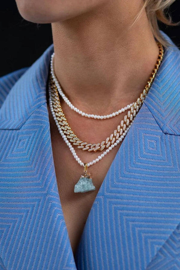 Model wearing the Aquamarine pendant in gold and blue colours from the brand CRYSTAL HAZE