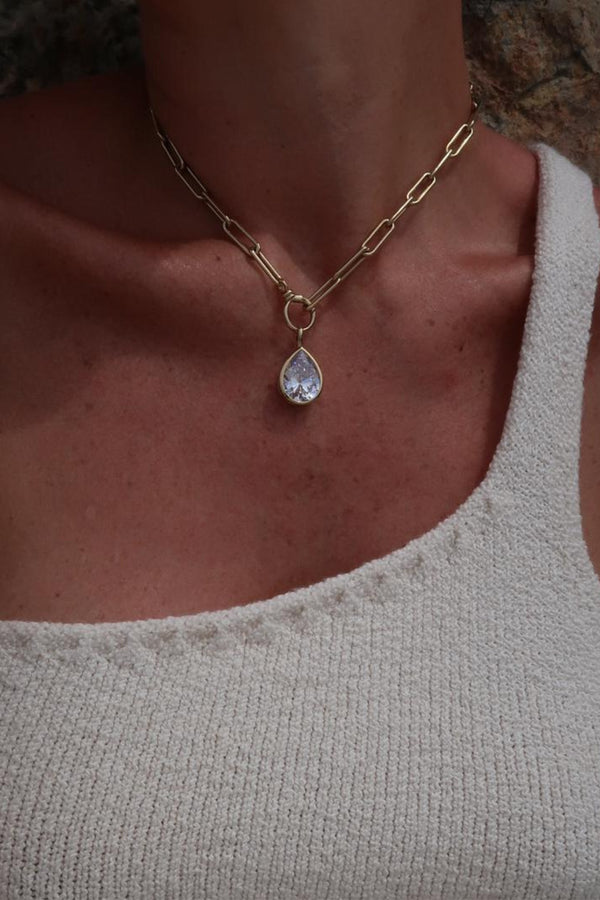 Model wearing the plain chain & drop pendant in gold and clear colours from the brand HEAVENLY LONDON
