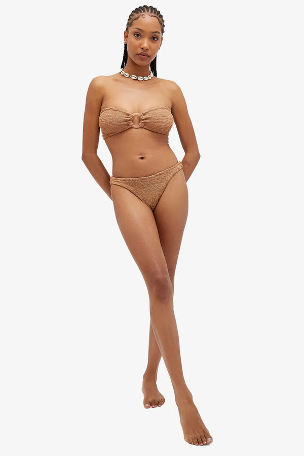 Model wearing the Gloria Ring-Detail Bandeau Bikini in Metallic Cocoa colour from the brand HUNZA G