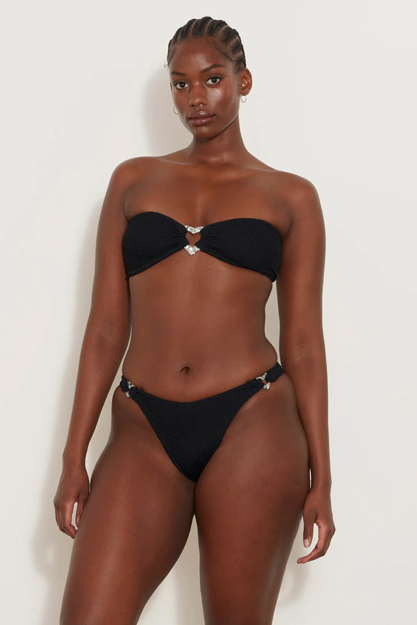 Model wearing the Nicole heart-embellished bandeau bikini in black color from the brand HUNZA G