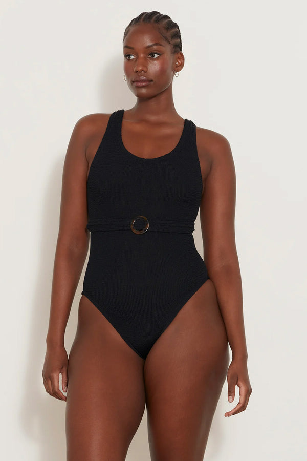 Model wearing the Solitaire belted swimsuit in black color from the brand HUNZA G