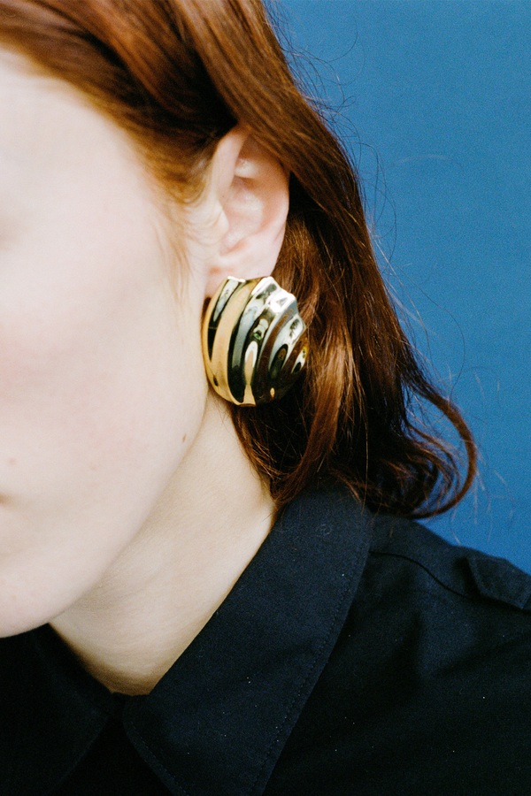 Model wearing the Ines stud earrings in gold colour from the brand JASMIN SPARROW