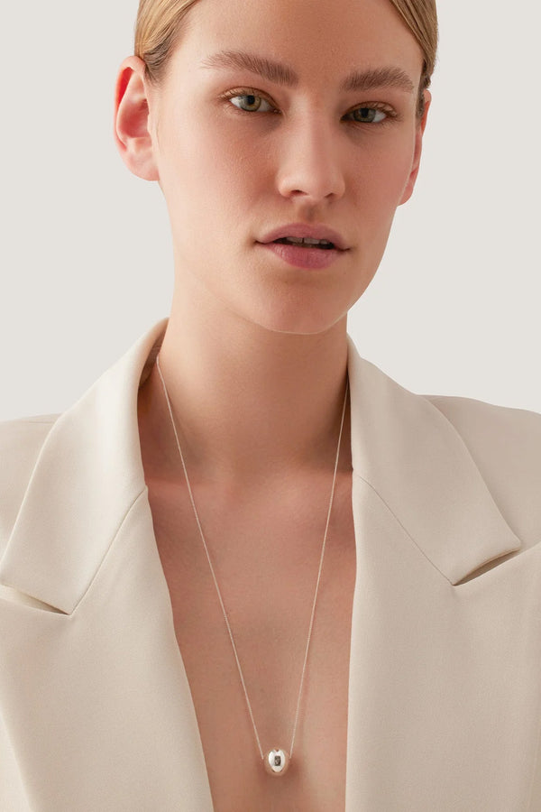 Model wearing the Aurora necklace in silver colour from the brand JENNY BIRD