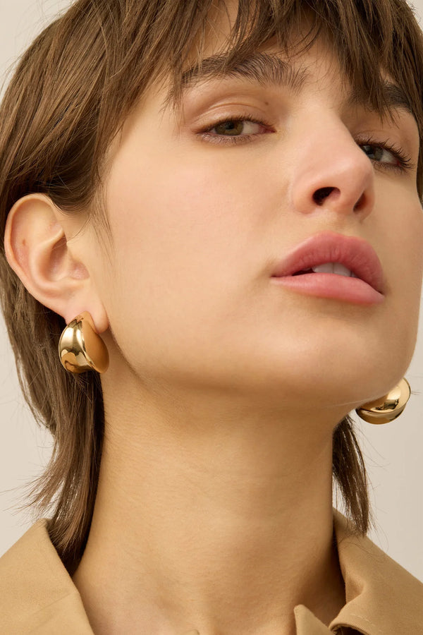 Model wearing the Nouveaux puff earrings in gold colour from the brand JENNY BIRD