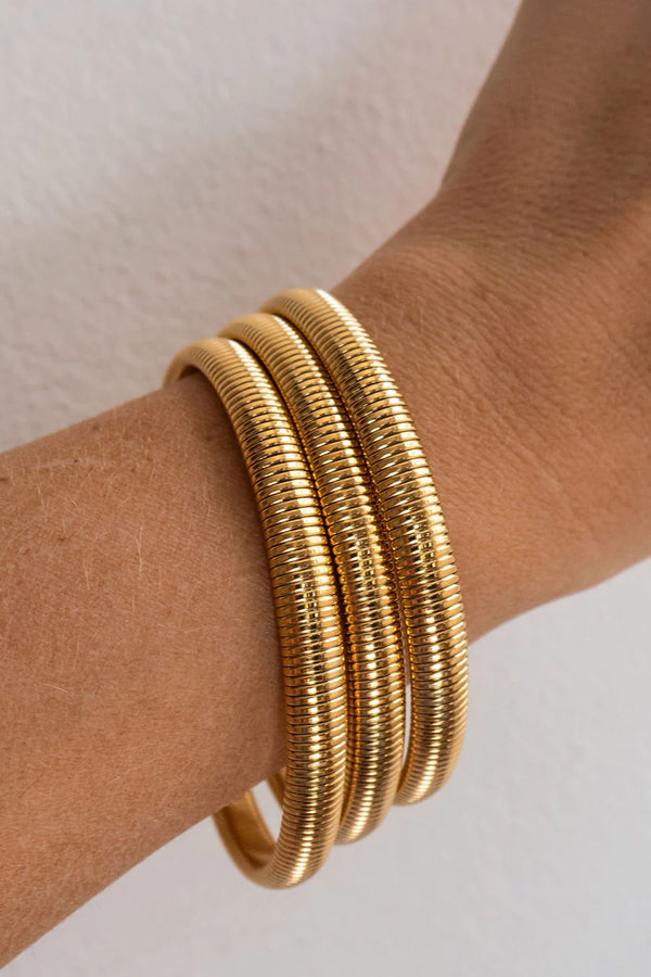 Model wearing the Mini Flex Snake chain bracelet set in gold colour from the brand LUV AJ