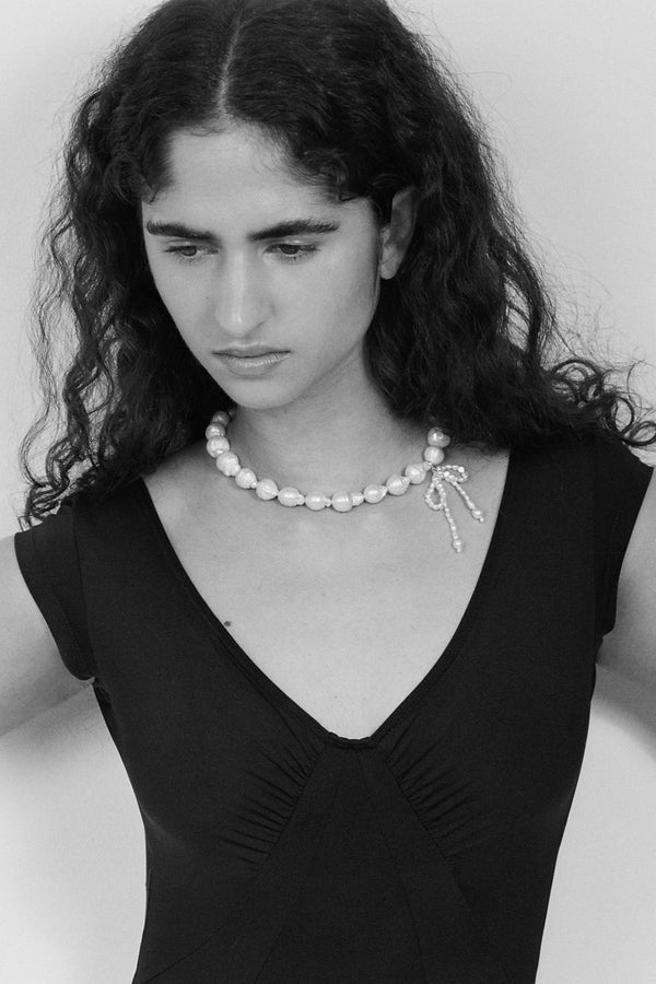 Model wearing the Chasing Her Dreams necklace in silver and pearl colours from the brand MARGAUX STUDIOS