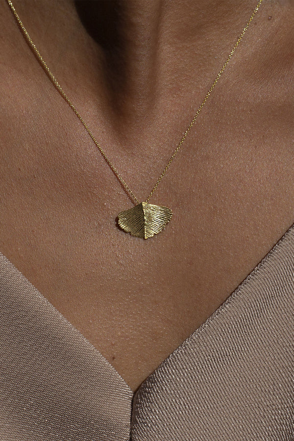 Model wearing the Ginkgo necklace in gold colour from the brand MESH