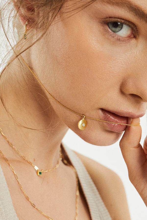 Model wearing the Mykos necklace in gold and clear colours from the brand MESH