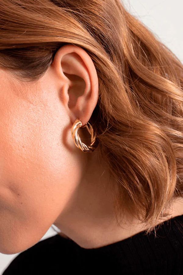 Model wearing the Tie In hoop earrings in gold colour from the brand MESH