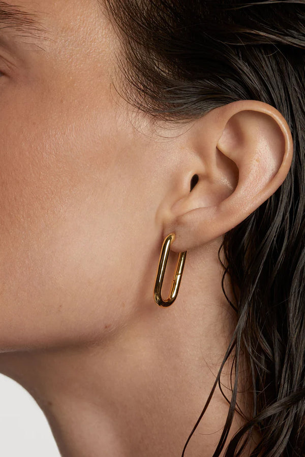Model wearing the Beat hoop earrings in gold colour from the brand P D PAOLA