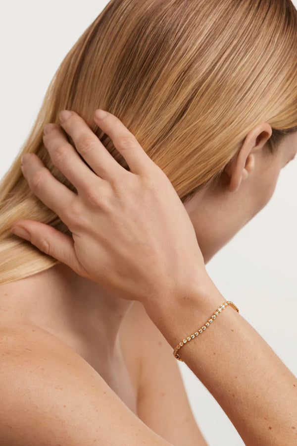 Model wearing the Florence bracelet in gold and clear colours from the brand P D PAOLA