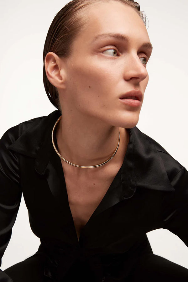 Model wearing the Pirouette necklace in gold colour from the brand P D PAOLA