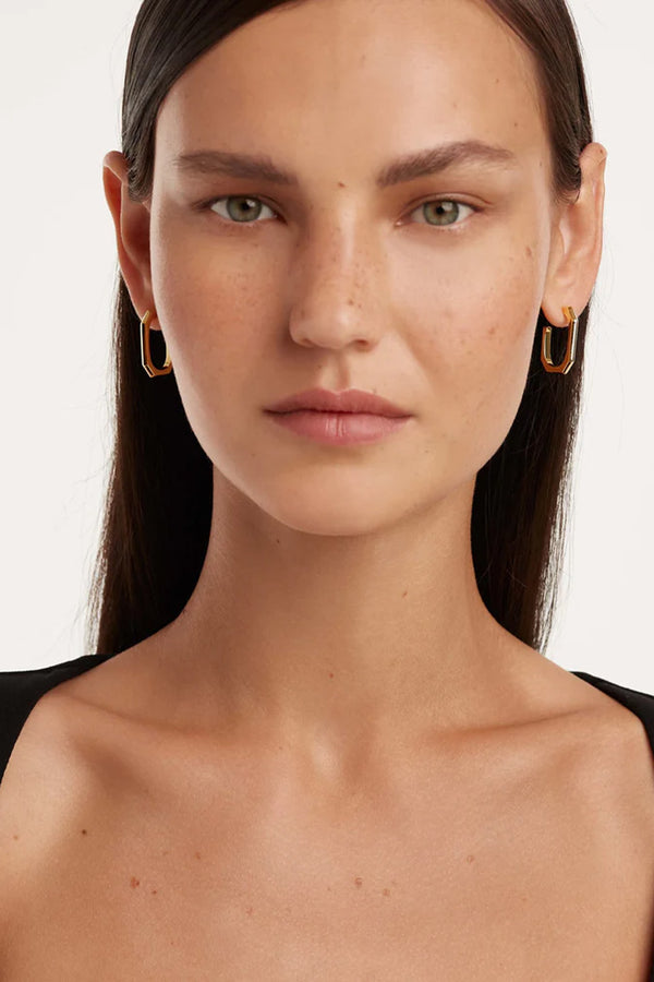 Model wearing the signature link earrings in gold colour from the brand P D PAOLA
