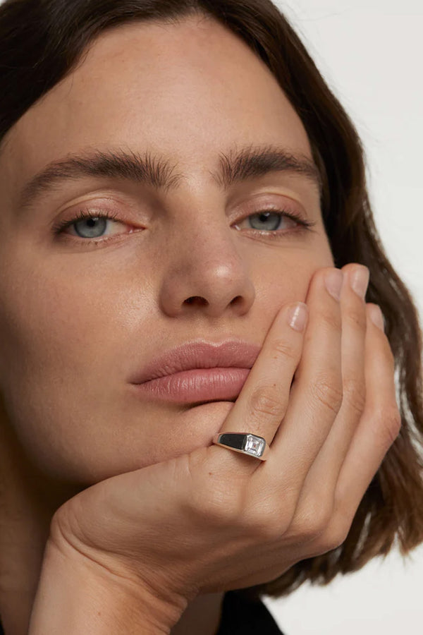 Model wearing the square Shimmer stamp ring in silver and clear colors from the brand P D PAOLA