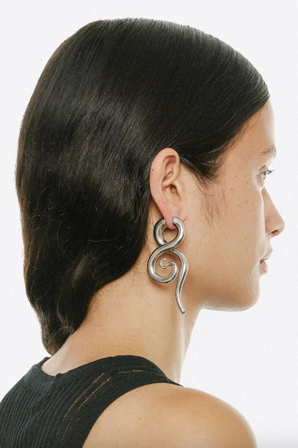 Model wearing the Boa medium earrings in silver colour from the brand PANCONESI