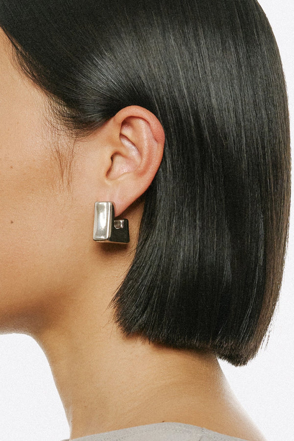 Model wearing the Cubo earrings in silver from the brand PANCONESI