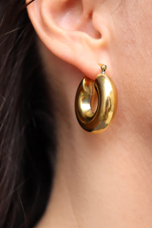 Model wearing the Mara chunky hoop earrings in gold colour from PICO COPENHAGEN