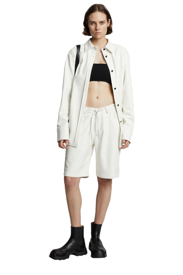 Model wearing the tie-waist vegan leather shirt jacket in off white color from the brand PROENZA SCHOULER