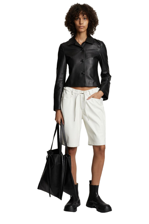 Model wearing the vegan leather midi shorts in off white color from the brand PROENZA SCHOULER