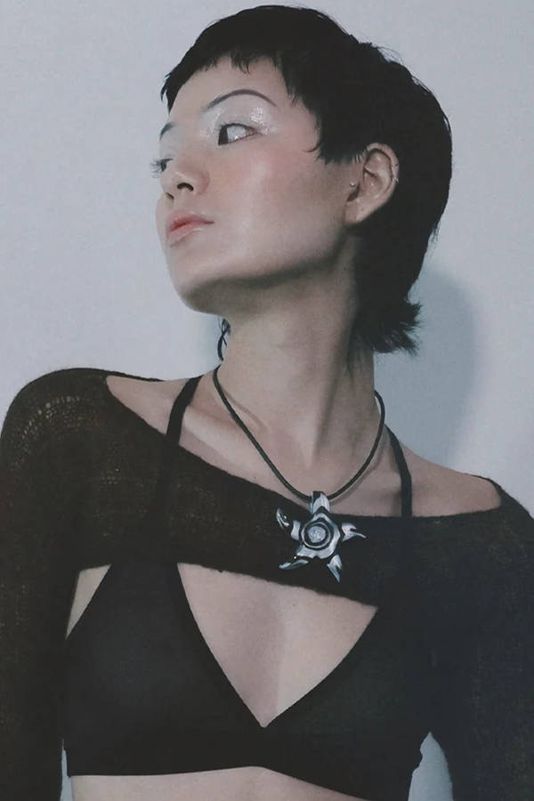 Model wearing the Spirit Star necklace in brown and blue colours from the brand THE GOOD STATEMENT