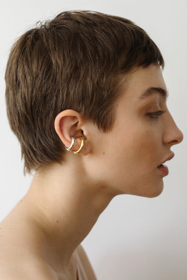 Model wearing the bold earcuff No3 in warm gold color from the brand Saskia Diez