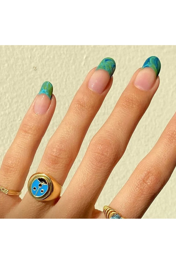 Model wearing the Ladybug ring in gold and blue colors from the brand WILHELMINA GARCIA